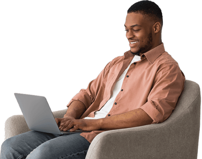 Homem sorrindo sentado com um notebook no seu colo