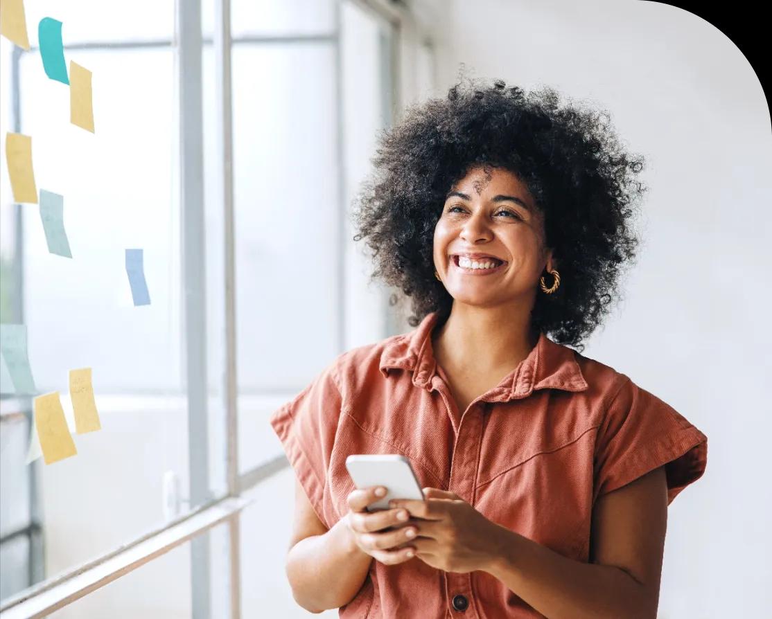 Mulher sorrindo com um smartphone na mão